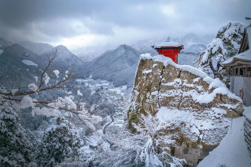 Risshaku-ji Buddhist temple in the snow, with the valley and town in the background. Risshaku-ji Buddhist temple in the snow, with the valley and town in the background.