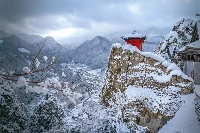 Risshaku-ji Buddhist temple in the snow, with the valley and town in the background. | ANDREW LEE