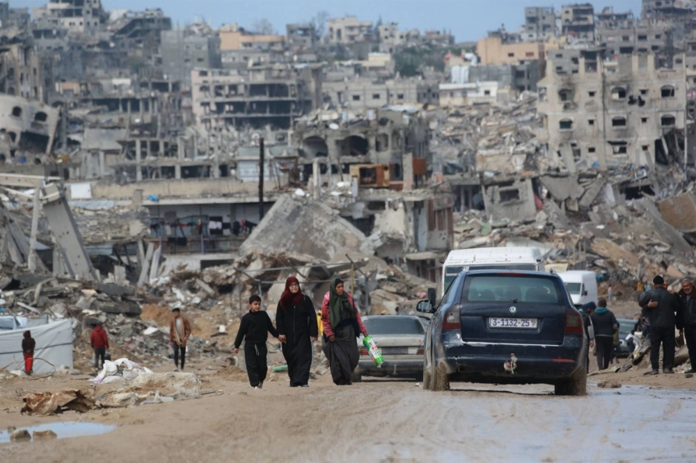 Displaced Palestinians walk through a muddy road amid the destruction in Jabalia in the northern Gaza Strip on Thursday. Displaced Palestinians walk through a muddy road amid the destruction in Jabalia in the northern Gaza Strip on Thursday.