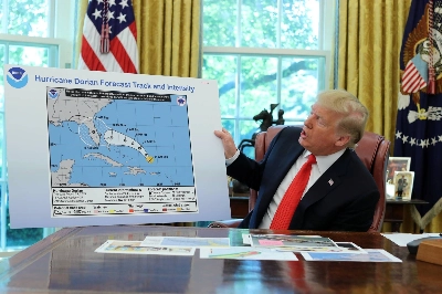 U.S. President Donald Trump receives a status report on Hurricane Dorian in the Oval Office in September 2019.  U.S. President Donald Trump receives a status report on Hurricane Dorian in the Oval Office in September 2019.