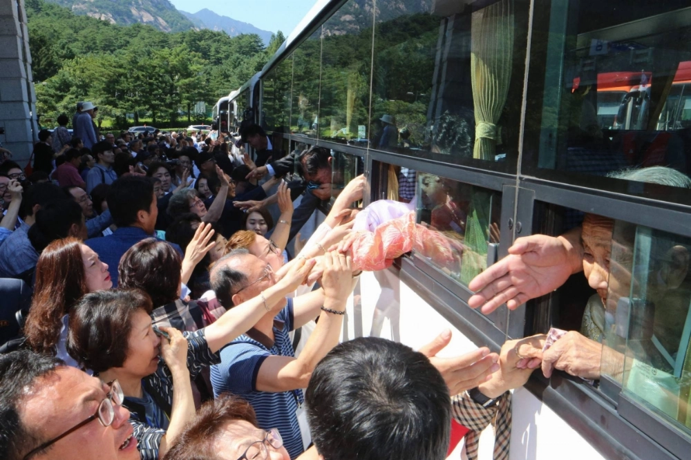 North Koreans on a bus hold the hands of their South Korean relatives as they bid farewell at the end of a three-day family reunion event at North Korea's Mount Kumgang resort in August 2018.  North Koreans on a bus hold the hands of their South Korean relatives as they bid farewell at the end of a three-day family reunion event at North Korea's Mount Kumgang resort in August 2018.
