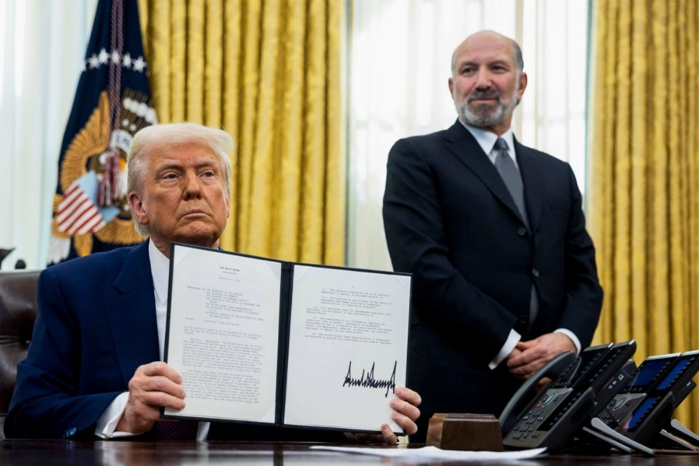 Howard Lutnick (right), chief executive officer of Cantor Fitzgerald and U.S. commerce secretary nominee for U.S. President Donald Trump, watches as Trump displays a signed executive order in the Oval Office of the White House in Washington on Thursday. Howard Lutnick (right), chief executive officer of Cantor Fitzgerald and U.S. commerce secretary nominee for U.S. President Donald Trump, watches as Trump displays a signed executive order in the Oval Office of the White House in Washington on Thursday.