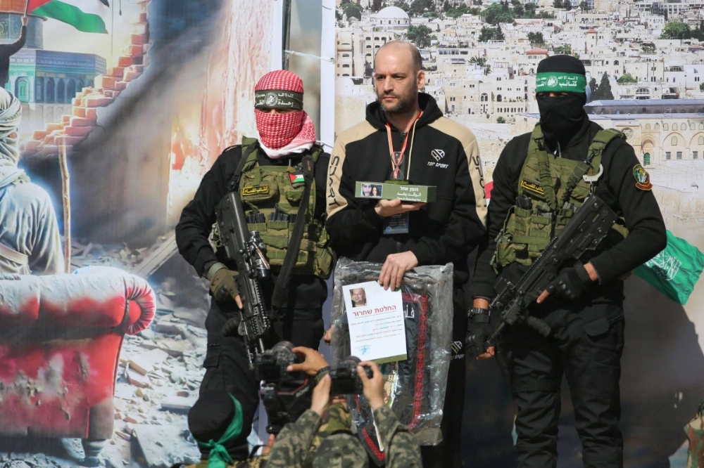 Israeli-Argentinian hostage Yair Horn (center) stands next to Palestinian militants as others take pictures of him on stage during a handover to a Red Cross team in Khan Younis, in the southern Gaza Strip, on Saturday as part of the sixth hostage-prisoner exchange. Israeli-Argentinian hostage Yair Horn (center) stands next to Palestinian militants as others take pictures of him on stage during a handover to a Red Cross team in Khan Younis, in the southern Gaza Strip, on Saturday as part of the sixth hostage-prisoner exchange.