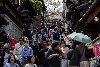 Visitors walk along the Sannenzaka approach in Kyoto in April 2024. Japan is targeting 60 million foreign tourists by 2030, up from a record of almost 37 million last year, highlighting an expected growth in flights — and aviation's carbon emissions. | Bloomberg