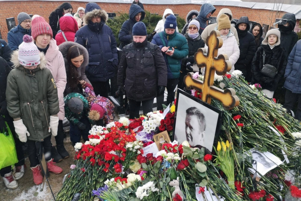 People pay tribute to late Russian opposition leader Alexei Navalny at his grave at the Borisovo cemetery, marking the first anniversary of his death while incarcerated in a remote Arctic penal colony, in Moscow on Sunday. People pay tribute to late Russian opposition leader Alexei Navalny at his grave at the Borisovo cemetery, marking the first anniversary of his death while incarcerated in a remote Arctic penal colony, in Moscow on Sunday.