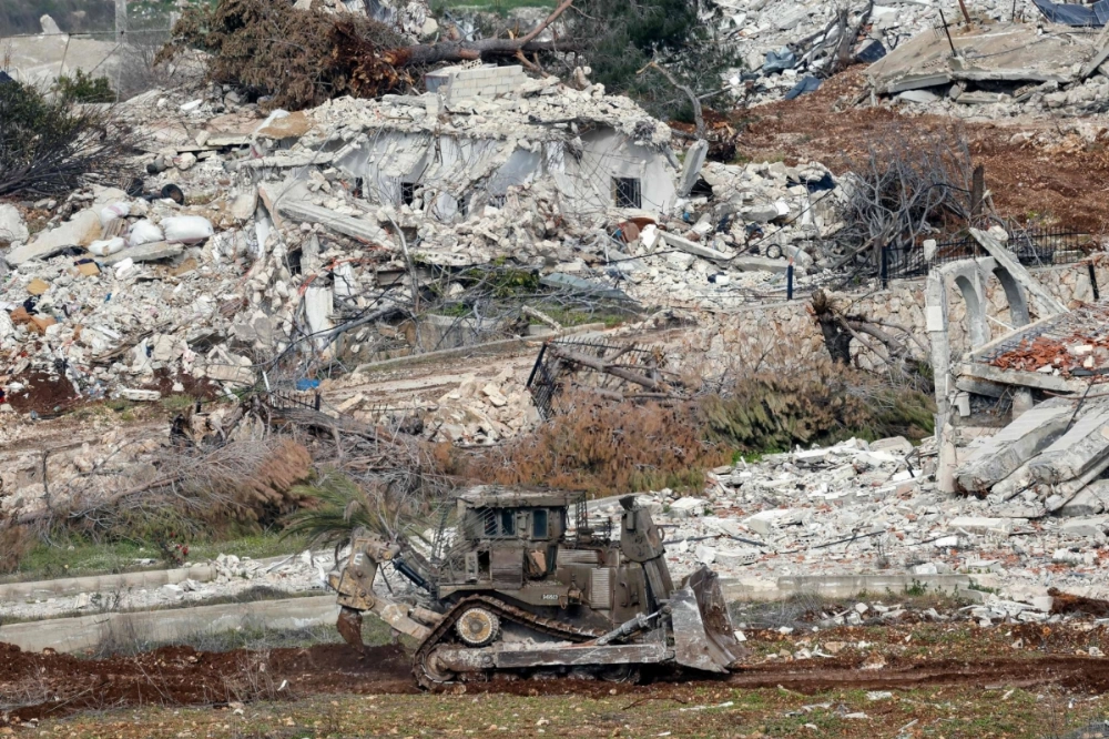 An Israeli military excavator drives past destroyed houses in the Lebanese village of Dhayra near the border with northern Israel, on Monday. An Israeli military excavator drives past destroyed houses in the Lebanese village of Dhayra near the border with northern Israel, on Monday.