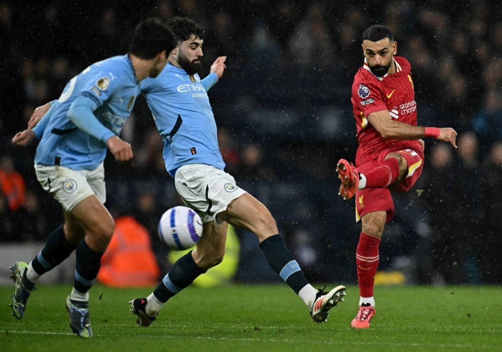 Liverpool's Mohamed Salah shoots past two Manchester City players during their match in Manchester, England, on Sunday. Liverpool's Mohamed Salah shoots past two Manchester City players during their match in Manchester, England, on Sunday.