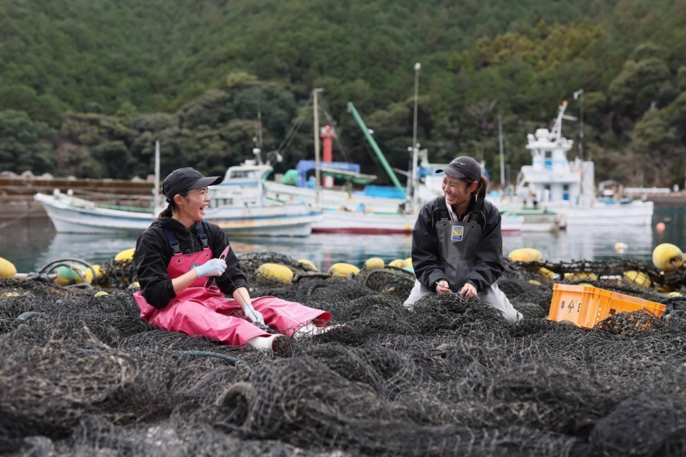 Maki Kanazawa (left) and Misaki Soejima repair a net in Owase, Mie Prefecture, on Jan. 27. Maki Kanazawa (left) and Misaki Soejima repair a net in Owase, Mie Prefecture, on Jan. 27.