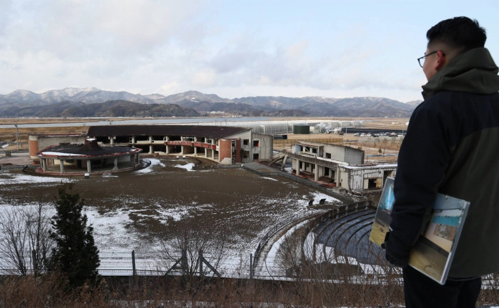 Tetsuya Tadano gazes at the school building from the hillside behind Okawa Elementary School on Feb. 7 in Ishinomaki, Miyagi Prefecture. Tetsuya Tadano gazes at the school building from the hillside behind Okawa Elementary School on Feb. 7 in Ishinomaki, Miyagi Prefecture.