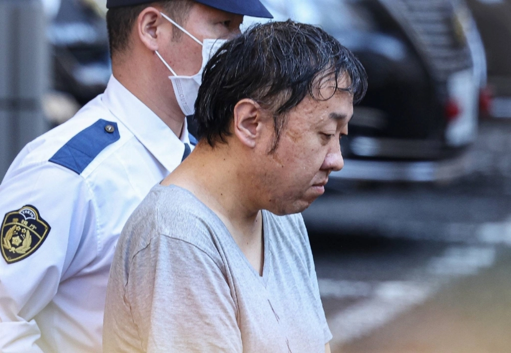 Kenichi Takano leaves a police station in Tokyo on Thursday to be sent over to prosecutors. Kenichi Takano leaves a police station in Tokyo on Thursday to be sent over to prosecutors.