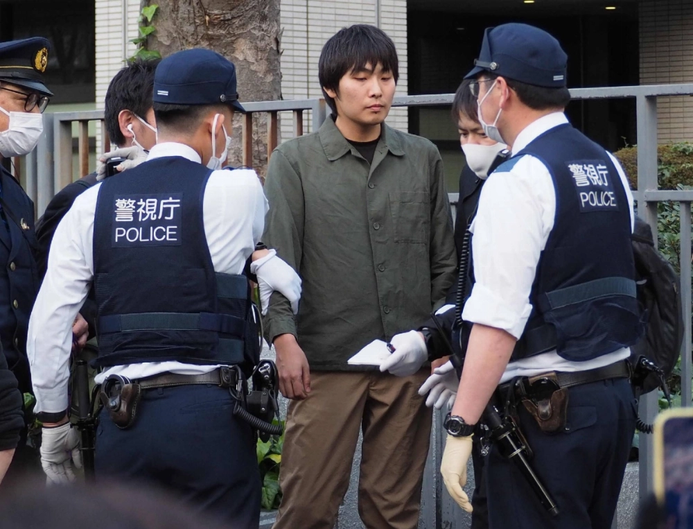 Shion Miyanishi (center) was arrested on the spot on Friday after attacking NHK Party head Takashi Tachibana in Tokyo.  Shion Miyanishi (center) was arrested on the spot on Friday after attacking NHK Party head Takashi Tachibana in Tokyo.