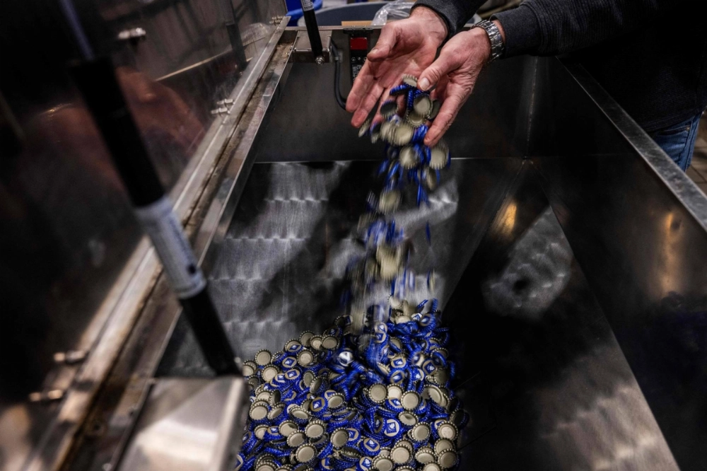 Port City Brewing Company founder and President Bill Butcher adds bottle caps, which he imports from Mexico, into the bottle machine at his brewery in Alexandria, Virginia, on Thursday. Port City Brewing Company founder and President Bill Butcher adds bottle caps, which he imports from Mexico, into the bottle machine at his brewery in Alexandria, Virginia, on Thursday.