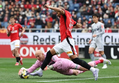Okayama goalkeeper Svend Brodersen reaches for the ball against Urawa's Thiago Santana (front) at Saitama Stadium on March 8. Okayama goalkeeper Svend Brodersen reaches for the ball against Urawa's Thiago Santana (front) at Saitama Stadium on March 8.