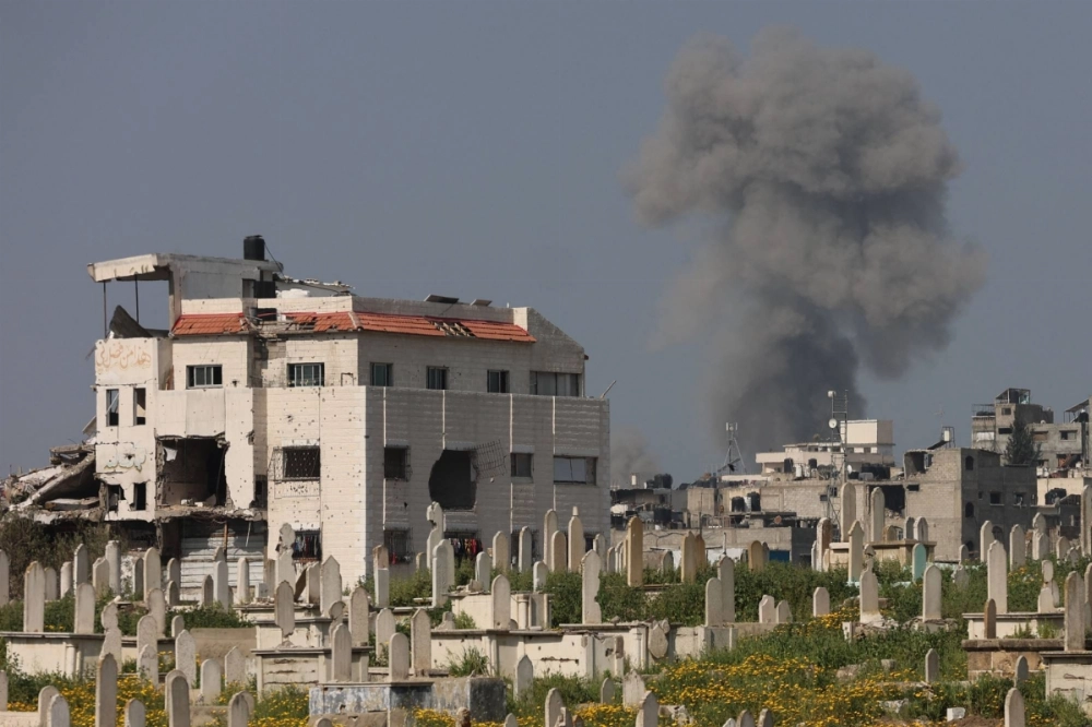 Smoke billows behind a cemetery (foreground) during Israeli strikes west of Gaza City, in the Gaza Strip, on Tuesday. Smoke billows behind a cemetery (foreground) during Israeli strikes west of Gaza City, in the Gaza Strip, on Tuesday.