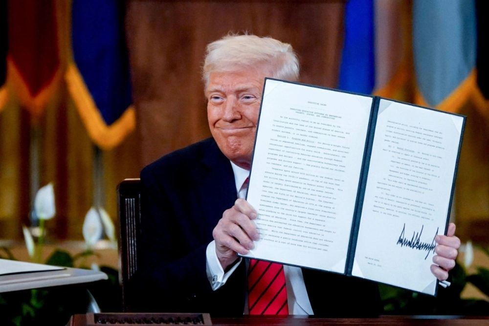 U.S. President Donald Trump holds up a signed executive order to shut down the Department of Education. U.S. President Donald Trump holds up a signed executive order to shut down the Department of Education.
