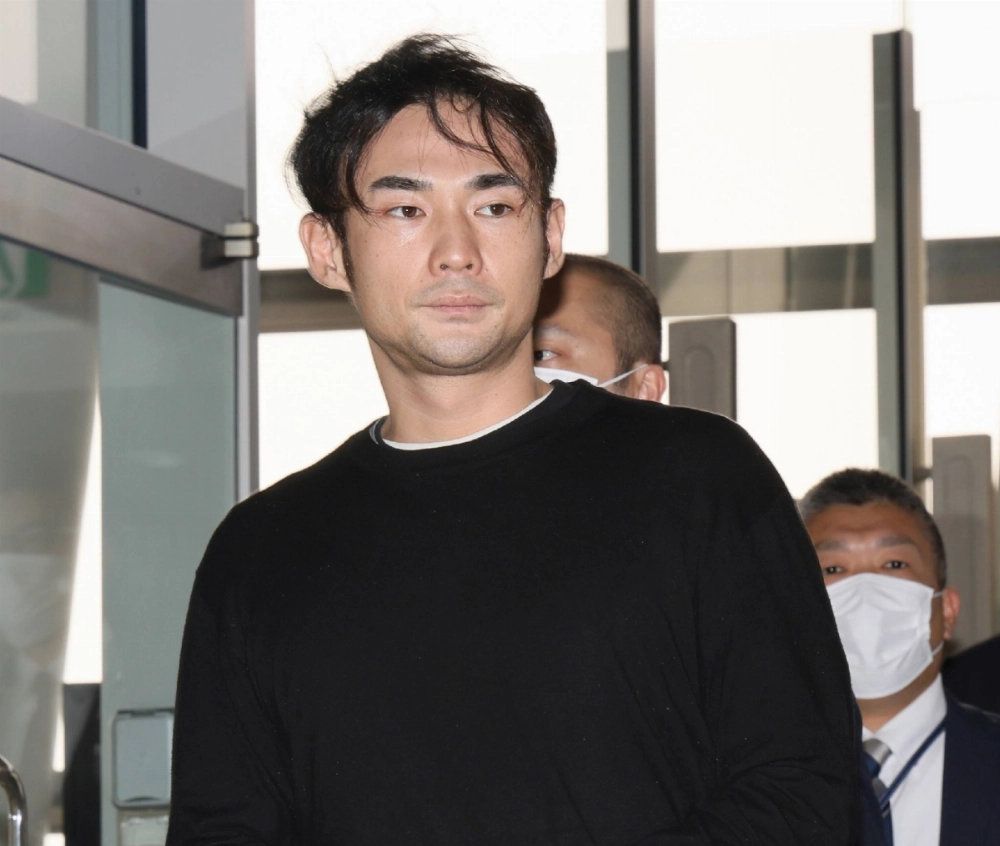 Tomu Fujinuma, suspect in a fraud case, is taken to Kansai International Airport from Thailand on Tuesday. Tomu Fujinuma, suspect in a fraud case, is taken to Kansai International Airport from Thailand on Tuesday.