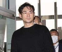 Tomu Fujinuma, suspect in a fraud case, is taken to Kansai International Airport from Thailand on Tuesday. | Jiji