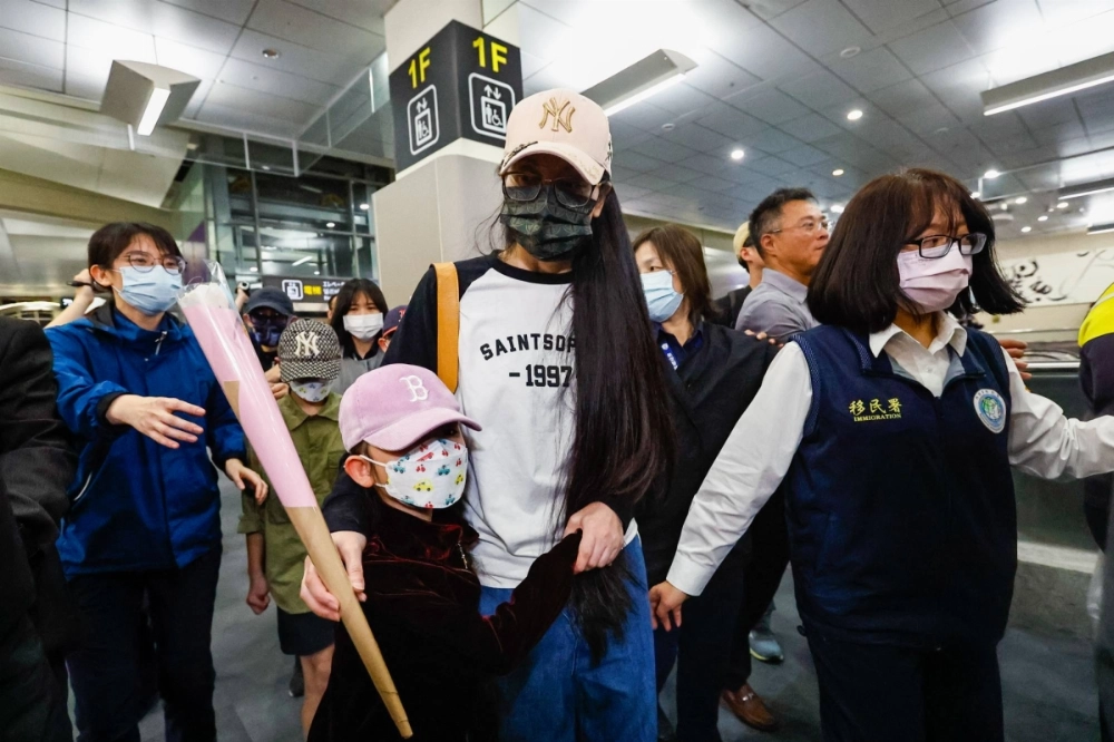 Liu Zhenya and her daughter are escorted by police and immigration officers at Songshan Airport in Taipei on Tuesday.  Liu Zhenya and her daughter are escorted by police and immigration officers at Songshan Airport in Taipei on Tuesday.
