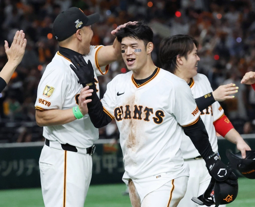 The Giants' Gakuto Wakabayashi (right) celebrates with Giants manager Shinnosuke Abe after his game-winning hit against the Swallows at Tokyo Dome on Friday. The Giants' Gakuto Wakabayashi (right) celebrates with Giants manager Shinnosuke Abe after his game-winning hit against the Swallows at Tokyo Dome on Friday.