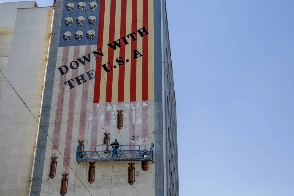 A worker restores an anti-U.S. mural in Tehran on Sunday. A worker restores an anti-U.S. mural in Tehran on Sunday.