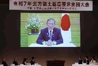 Prime Minister Shigeru Ishiba speaks in a video message shown at a national rally demanding the return of the Northern Territories held in Tokyo in February. | Jiji