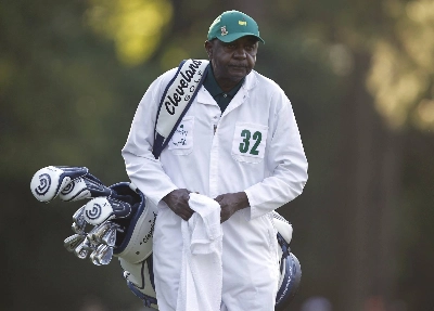 Caddie Carl Jackson carries the bag of former champion Ben Crenshaw during the first round of the 2011 Masters at Augusta National Golf Club in Augusta, Georgia. 
 Caddie Carl Jackson carries the bag of former champion Ben Crenshaw during the first round of the 2011 Masters at Augusta National Golf Club in Augusta, Georgia.
