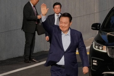 Ousted South Korean President Yoon Suk Yeol waves before leaving the presidential residence in Seoul on Friday.  Ousted South Korean President Yoon Suk Yeol waves before leaving the presidential residence in Seoul on Friday.
