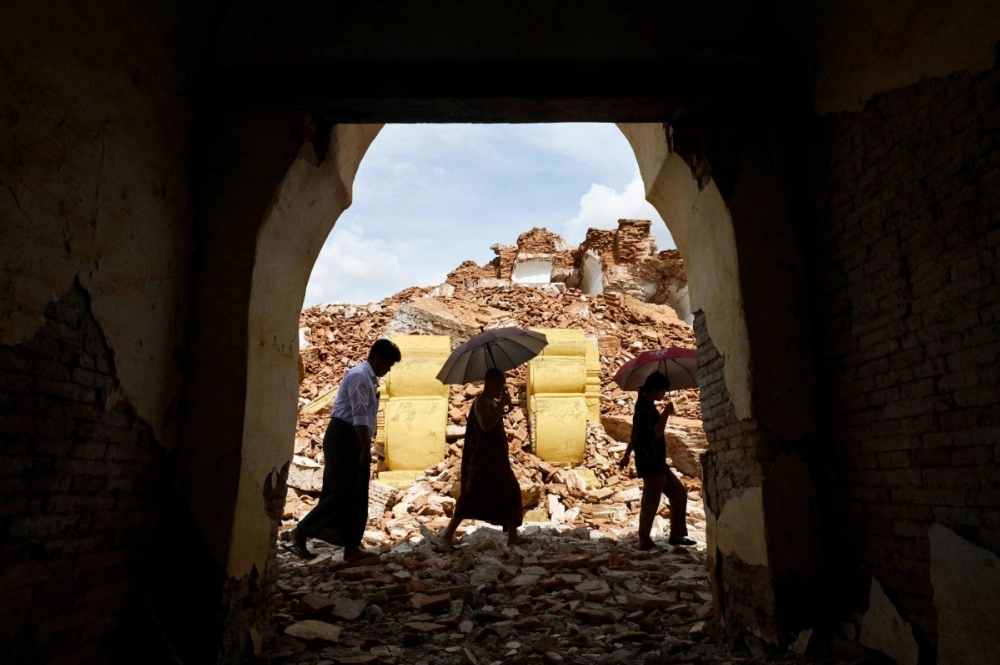 People walk past debris in the damaged Me Nu Brick monastery on the outskirts of Mandalay, Myanmar, on Saturday. People walk past debris in the damaged Me Nu Brick monastery on the outskirts of Mandalay, Myanmar, on Saturday.