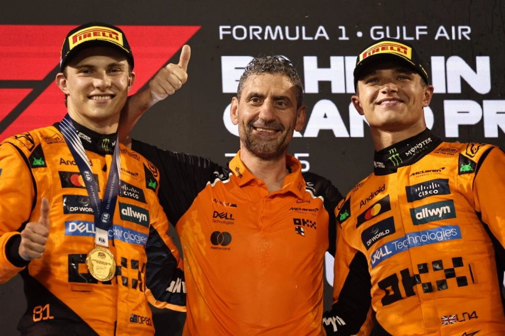 McLaren drivers Oscar Piastri (left) and Lando Norris (right) celebrate with team principal Andrea Stella after the Bahrain Grand Prix in Sakhir, Bahrain, on Sunday.  McLaren drivers Oscar Piastri (left) and Lando Norris (right) celebrate with team principal Andrea Stella after the Bahrain Grand Prix in Sakhir, Bahrain, on Sunday.