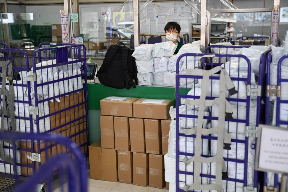 Stacked parcels are seen as an employee stands at a service counter at a post office in Hong Kong on Wednesday. Stacked parcels are seen as an employee stands at a service counter at a post office in Hong Kong on Wednesday.
