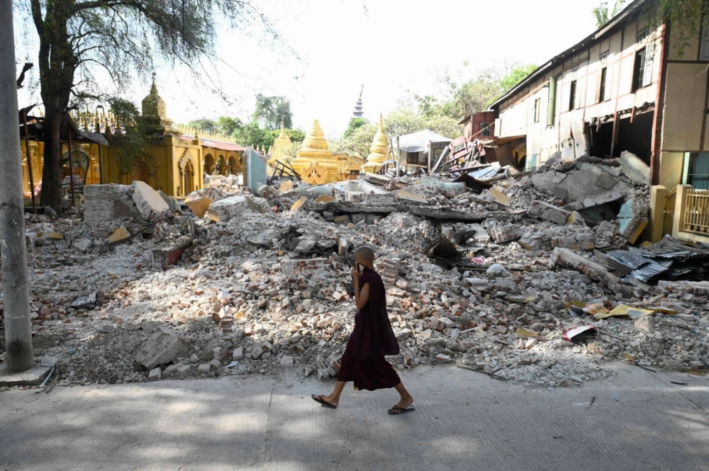 A Buddhist monk walks past the debris of a collapsed building in Mandalay, Myanmar, on Saturday. A Buddhist monk walks past the debris of a collapsed building in Mandalay, Myanmar, on Saturday.