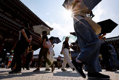 People walk near Tokyo's Sensoji temple in July 2024 amid a heat wave.  People walk near Tokyo's Sensoji temple in July 2024 amid a heat wave.