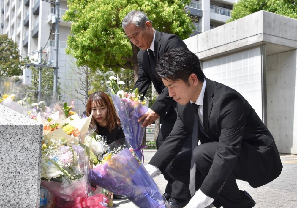 Takuya Matsunaga (right), who lost his wife, Mana, and daughter, Riko, in a 2019 crash lays flowers next to Mana's father, Yoshinori Uehara, at the site of the crash, in Tokyo on Saturday.  Takuya Matsunaga (right), who lost his wife, Mana, and daughter, Riko, in a 2019 crash lays flowers next to Mana's father, Yoshinori Uehara, at the site of the crash, in Tokyo on Saturday.