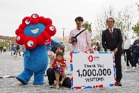 Makoto Miyamori (second from the right) receives commemorative gifts with his family as the 1 millionth visitor to the expo on Wednesday in the city of Osaka.  | Jiji