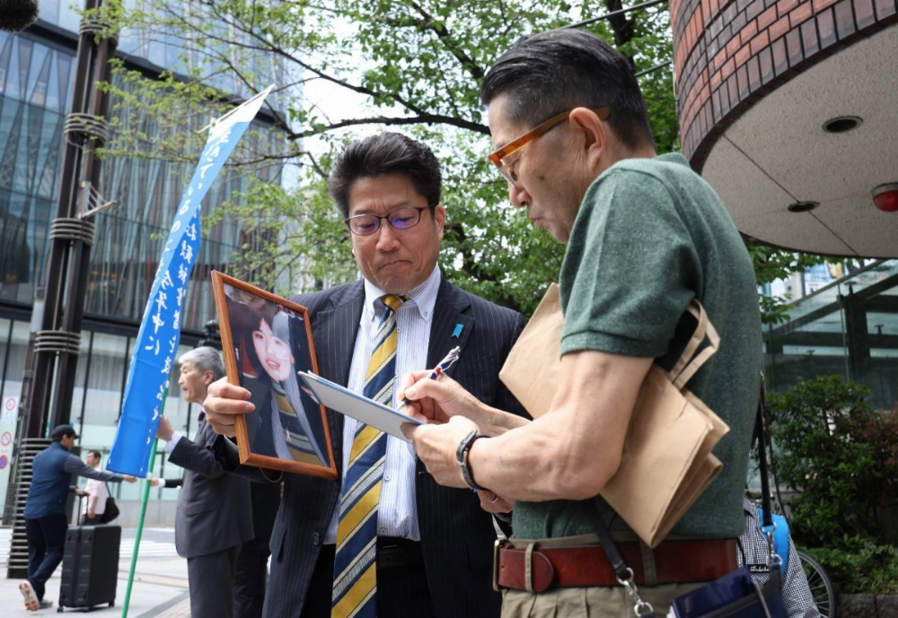 Takuya Yokota, the leader of a group of families of Japanese citizens abducted by North Korea decades ago (left), asks people for signatures to seek their return during a campaign held in Tokyo on Saturday. Takuya Yokota, the leader of a group of families of Japanese citizens abducted by North Korea decades ago (left), asks people for signatures to seek their return during a campaign held in Tokyo on Saturday.