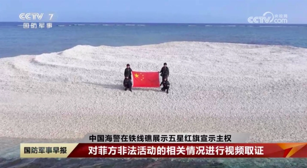 China Coast Guard officers unfurl a national flag on Sandy Cay reef, near the Philippine-held Thitu Island, in disputed waters of the South China Sea this month in this screen shot taken from Chinese state broadcaster CCTV. China Coast Guard officers unfurl a national flag on Sandy Cay reef, near the Philippine-held Thitu Island, in disputed waters of the South China Sea this month in this screen shot taken from Chinese state broadcaster CCTV.