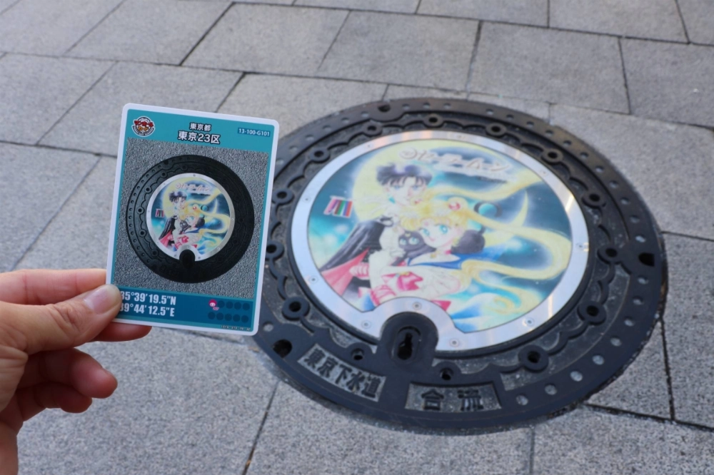 A manhole card and a manhole cover featuring characters from "Sailor Moon," on Feb. 10. The cards were handed out by Tokyo's Minato Ward, where the series is set. A manhole card and a manhole cover featuring characters from "Sailor Moon," on Feb. 10. The cards were handed out by Tokyo's Minato Ward, where the series is set.