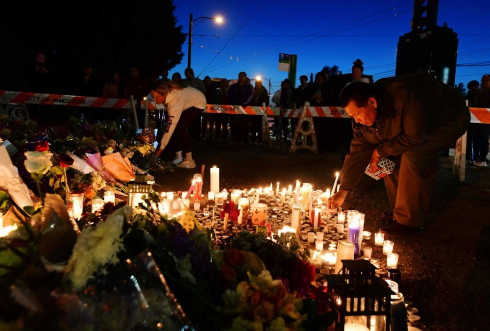 A man places a lit candle at a vigil at 41st and Fraser street in Vancouver on Sunday, a day after a car drove into a crowd during the Lapu Lapu Festival, killing at least 11. The suspect in the attack has been charged with murder. A man places a lit candle at a vigil at 41st and Fraser street in Vancouver on Sunday, a day after a car drove into a crowd during the Lapu Lapu Festival, killing at least 11. The suspect in the attack has been charged with murder.