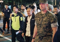 Okinawa Gov. Denny Tamaki (center) takes part in a joint patrol involving the U.S. military and the Okinawa Prefectural Police in the city of Okinawa on April 18. | Jiji