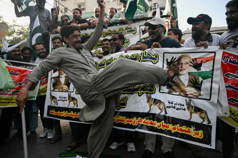 A trader kicks a picture of Indian Prime Minister Narendra Modi during a protest in Karachi on Tuesday.  A trader kicks a picture of Indian Prime Minister Narendra Modi during a protest in Karachi on Tuesday.