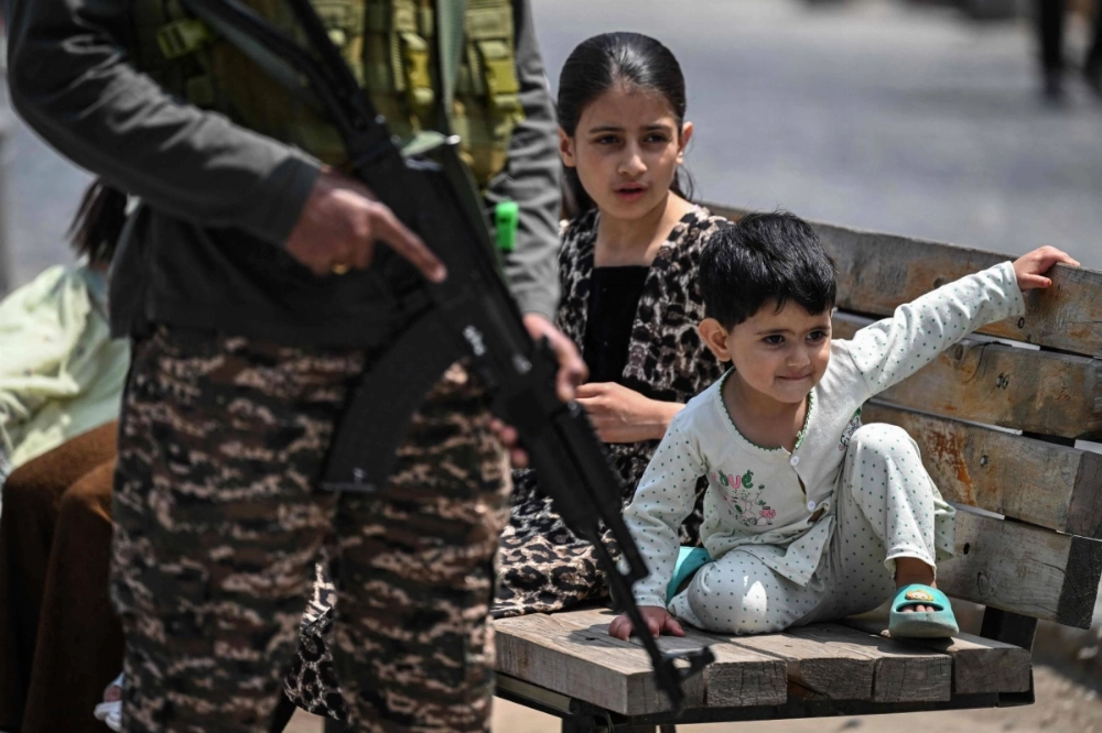 Kashmiri children sit on a bench at a marketplace as an Indian paramilitary soldier keeps guard along a street in Srinagar in Indian-controlled Kashmir on Sunday. Tensions between the nuclear-armed archrivals have soared since India accused Pakistan of backing a shooting that killed 26 civilians on the Indian side of the disputed territory on April 22.  Kashmiri children sit on a bench at a marketplace as an Indian paramilitary soldier keeps guard along a street in Srinagar in Indian-controlled Kashmir on Sunday. Tensions between the nuclear-armed archrivals have soared since India accused Pakistan of backing a shooting that killed 26 civilians on the Indian side of the disputed territory on April 22.