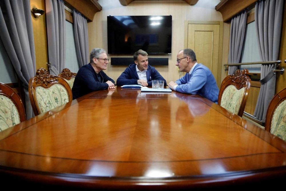 French President Emmanuel Macron (center), British Prime Minister Keir Starmer (left) and German Chancellor Friedrich Merz hold a trilateral meeting on board a train to Ukraine on Friday. French President Emmanuel Macron (center), British Prime Minister Keir Starmer (left) and German Chancellor Friedrich Merz hold a trilateral meeting on board a train to Ukraine on Friday.