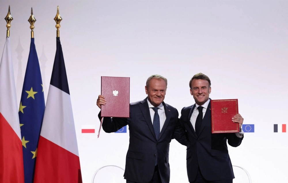 French President Emmanuel Macron (right) and Polish Prime Minister Donald Tusk pose after signing the French-Polish Friendship and Strategy Pact following their meeting at the Nancy's town hall on Stanislas square in Nancy, eastern France, on Friday.  French President Emmanuel Macron (right) and Polish Prime Minister Donald Tusk pose after signing the French-Polish Friendship and Strategy Pact following their meeting at the Nancy's town hall on Stanislas square in Nancy, eastern France, on Friday.