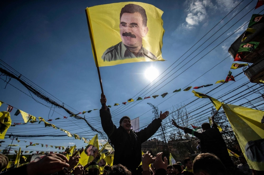 A protester waves a flag bearing a portrait of Abdullah Ocalan, the leader of the Kurdistan Worker's Party (PKK) jailed in Turkey since 1999, during a demonstration calling for his release in the Kurdish-majority city of Qamishli in northeastern Syria on Feb. 15. A protester waves a flag bearing a portrait of Abdullah Ocalan, the leader of the Kurdistan Worker's Party (PKK) jailed in Turkey since 1999, during a demonstration calling for his release in the Kurdish-majority city of Qamishli in northeastern Syria on Feb. 15.