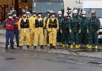 Firefighters see off a vehicle carrying a body recovered from a sinkhole in Yashio, Saitama Prefecture, on May 2. | Jiji
