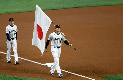 Japan's Shohei Ohtani carries the Japanese flag onto the field before the start of the World Baseball Classic final against the United States in Miami on March 21, 2023. Japan's Shohei Ohtani carries the Japanese flag onto the field before the start of the World Baseball Classic final against the United States in Miami on March 21, 2023.