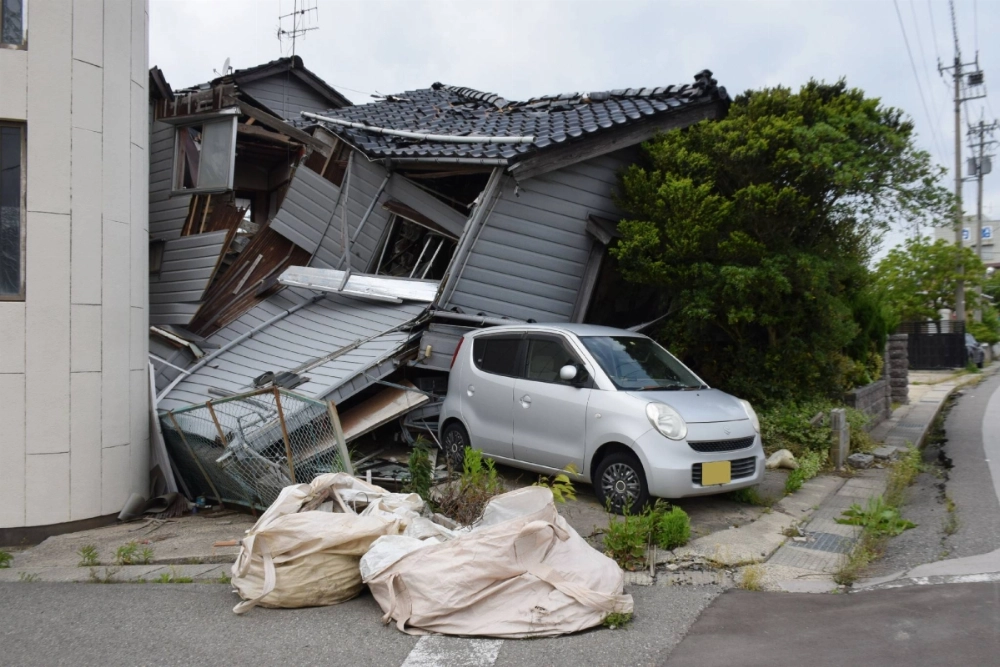 A vacant house in Wajima, Ishikawa Prefecture, which collapsed following the January 2024 earthquake, is left untouched on May 12 as its owner cannot be identified. The car's license plate has been blurred for privacy reasons. A vacant house in Wajima, Ishikawa Prefecture, which collapsed following the January 2024 earthquake, is left untouched on May 12 as its owner cannot be identified. The car's license plate has been blurred for privacy reasons.