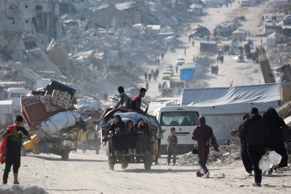 Palestinians carry their belongings through the town of Jabalia as they flee the southward toward Gaza City on Monday. Palestinians carry their belongings through the town of Jabalia as they flee the southward toward Gaza City on Monday.