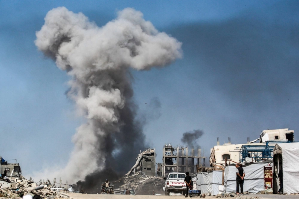 People watch as smoke billows following an Israeli strike in Jabalia, in the northern Gaza Strip on Sunday. People watch as smoke billows following an Israeli strike in Jabalia, in the northern Gaza Strip on Sunday.