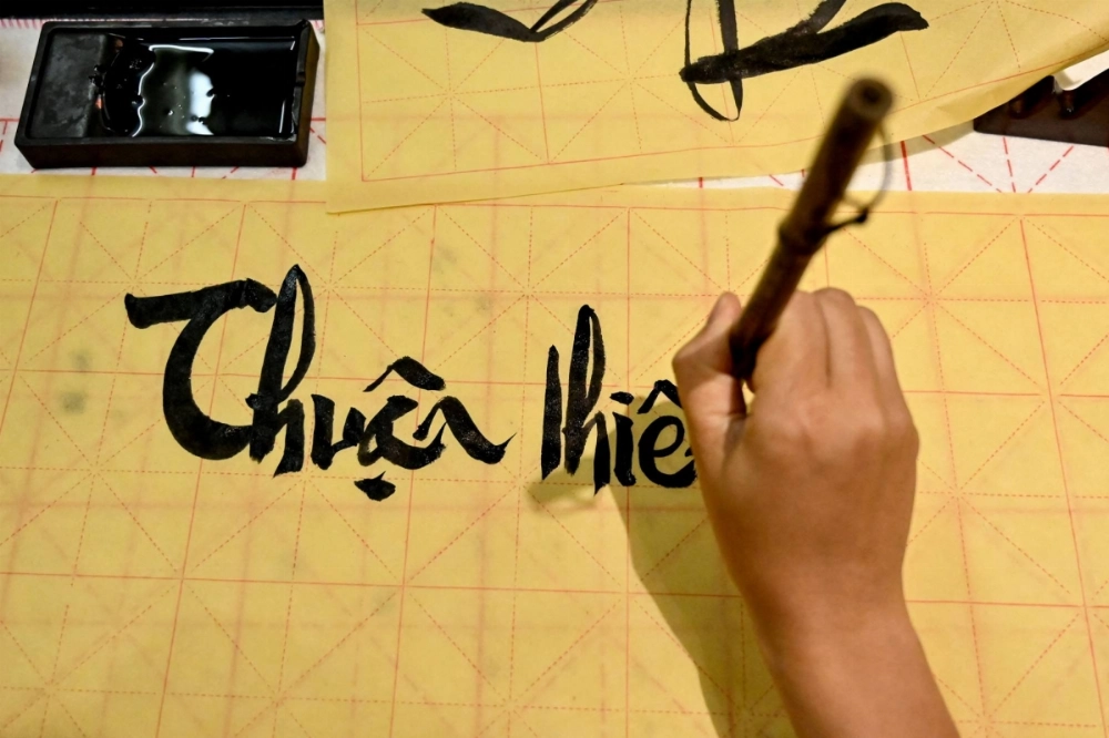 At a calligraphy class in Hanoi, Hoang Thi Thanh Huyen slides her brush across the page to form the letters and tonal marks of Vietnam's unique modern script, in part a legacy of French colonial rule. At a calligraphy class in Hanoi, Hoang Thi Thanh Huyen slides her brush across the page to form the letters and tonal marks of Vietnam's unique modern script, in part a legacy of French colonial rule.